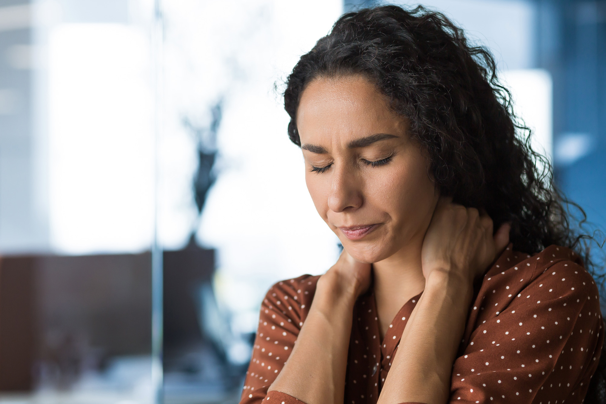 A person rubs the back of their neck.