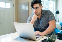 a Hispanic man on computer