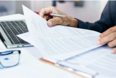 A man reading documents on desk.