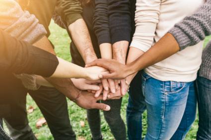 Multiracial group of friends with hands in stack