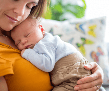 Image shows woman holding an infant.