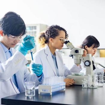 three scientists at a workbench