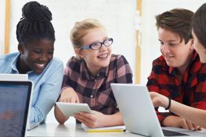 Middleschoolers at a desk on computers