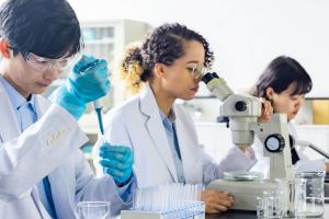 three scientists at a workbench